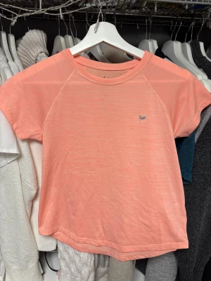 Rosa tränings t-shirt storlek 146/152 - Materialet är lätt och andas, perfekt för aktiva dagar. Diskret logga på bröstet och meshpanel i ryggen för extra ventilation. Storlek 146/152