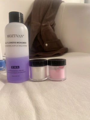 MOZTVAN akryl nagelkit - Säljer ett akryl nagelkit från MOZTVAN med en lila monomer (75 ml) och två burkar akrylpulver i vitt och ljusrosa. Perfekt för att skapa snygga och hållbara naglar hemma. Allt kommer i praktiska plastburkar med svarta lock.