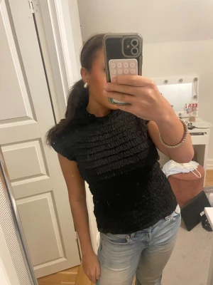 Svart ribbad topp med hög hals - Säljer en svart ribbad topp med hög hals och korta ärmar. Inget trasigt 🥰