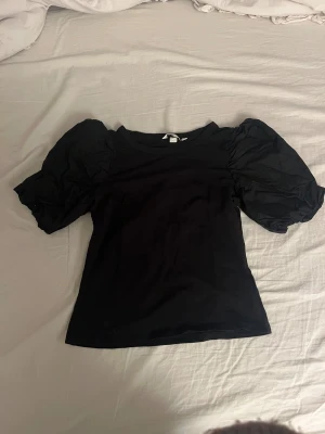 Svart topp med puffärmar - Säljer en jätte fin svart topp med puffärmar som tyvärr är för liten för mig.💕