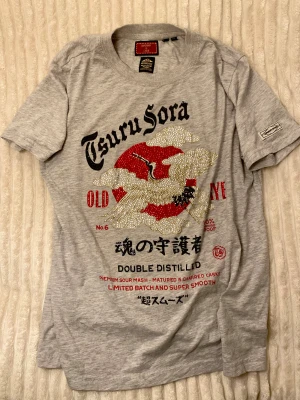  T-shirt paljett tryck - Limited Edition tröja köpt från en exklusiv butik i Jordanien, mannen köper helt nya  tröjor från Turkiet för bästa kvalité. Tröjan är en collab med Superdry. En japansk inspirerat tryck framtill. Storlek passar för oss som är M och har mellan stor byst tex 85E. Materialet är mjukt,  allt sitter kvar i bra kvalité! Den är limited edition, ingen kommer att ha likadant som dig. 🖤 Passar för oss som gillar unika prints och streetstyle, gillar du unik mode? Then get this DRIP ;)