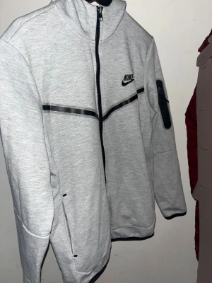 Grå Nike tech full dress - Snygga ljusgrå nike tech dress som inte långre kommer till användning.