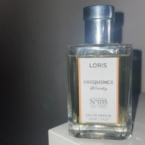 Loris Frequence Woody EdP - Loris Frequence Woody N°035 for man är en Eau de Parfum med en volym på 50 ml. Modern och stilren parfym som passar dig som vill sticka ut med en unik doftprofil. Perfekt storlek för att ta med sig överallt.