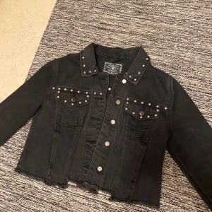Jeansjacka - En svart croppad jeansjacka med silver knoppar/detaljer. Begagnad men själv aldrig använt. Strl 36☺️