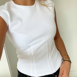 Topp - Vit topp med lite detaljer som ger en figursydd känsla😊