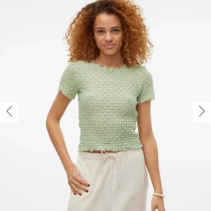 Ljusblå ribbad topp med kort ärm - Superfin ljusgrön topp med korta ärmar och ribbad struktur. Toppen har en lätt croppad passform och vågig kant nertill och vid ärmslut. Perfekt för dig som gillar en söt och trendig stil. MIN ÄR BLÅ