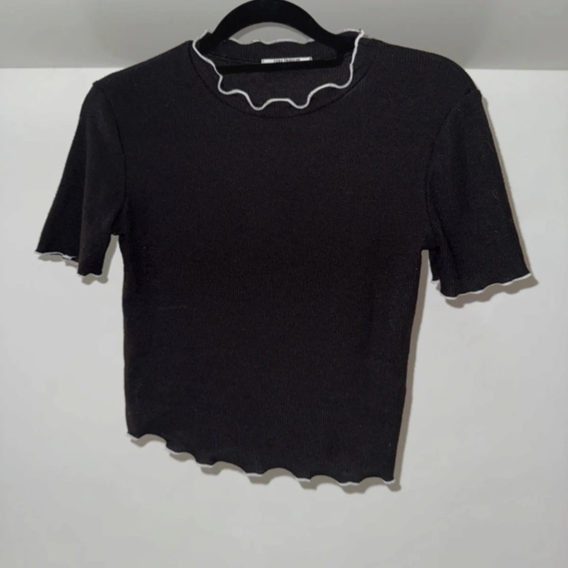 Svart ribbad topp med vita vågig kanter