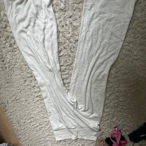 Vita ribbade mjukisbyxor - Säljer ett par vita mjukisbyxor med ribbad struktur. Byxorna har en avslappnad passform och är perfekta för chill dagar hemma. Mjukt och bekvämt material som känns skönt mot huden.