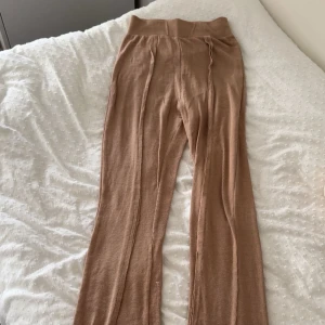 Beige ribbade byxor Public Desire - Säljer ett par beige ribbade byxor från Public Desire i storlek 34. Byxorna har hög midja, tight passform och dekorativa sömmar längs benen. Mjukt och stretchigt material som sitter snyggt och bekvämt.
