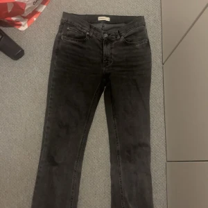 Svarta bootcut jeans från Gina Tricot - Säljer ett par svarta bootcut jeans från Gina Tricot i modellen 'perfect jeans'. Klassisk femficksdesign, normal passform och snyggt utsvängda ben. Perfekta för dig som gillar en tidlös look med lite edge.