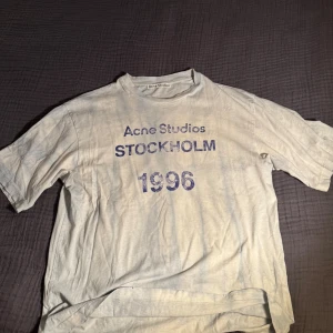 Vit Acne Studios t-shirt XS - Vit t-shirt från Acne Studios i storlek XS med tryck i blått framtill: 'Acne Studios STOCKHOLM 1996'. Sitter som en herr storlek M.