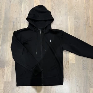 Svart Ralph lauren zip hoodie - Säljer nu en riktigt fet Ralph Lauren zip hoodie ⭐️. Hoodien är storlek M men kan passa S också. Köpt på plick. Hör av er vid funderingar! 