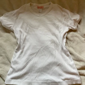 Vit topp/tshirt - Vit t-shirt från She's a Girl med v-ringning och korta ärmar. Storlek S/M men står 42/44 på lappen. Pris kan diskuteras🙏