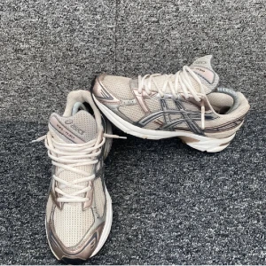 Asics Gel-1130 sneakers beige/grå - Säljer ett par Asics Gel-1130 sneakers i beige och grå med silvriga detaljer. Skorna har mesh- och syntetmaterial, klassisk snörning och en chunky sula. Perfekta för dig som gillar sportig och trendig stil.