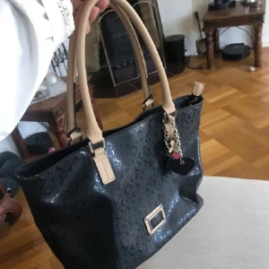 Svart handväska från Guess med logomönster - Använd i nått år men fint skicka ändå. 