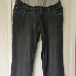 Svarta slim jeans från Mamalicious - Svarta slim fit jeans från Mamalicious med klassisk femficksdesign. Jeansen har en rak siluett och är tillverkade i bomull, polyester och elastan. Perfekta för dig som gillar en enkel och stilren look. Dom är välanvända och visst slitage syns vid benslut och fickor. Det har dessutom blivit ett hål en bit nedanför grenen på höger ben som säkert är värt att laga om man inte är färdig med att vara gravid. Jag hittar ingen storleksmärkning men skulle säga att de är i stl L.