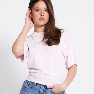 Ljusrosa t-shirt i bomull - Enkel och stilren ljusrosa t-shirt med korta ärmar och rund hals. T-shirten har en loose passform.