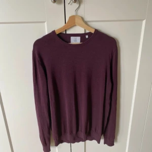 Vinröd stickad tröja från Bläck (prisförslag) - Vinröd stickad tröja från Bläck i storlek L. Enkel och stilren modell med rund halsringning och långa ärmar. Perfekt för lager-på-lager och passar snyggt till både jeans och chinos.