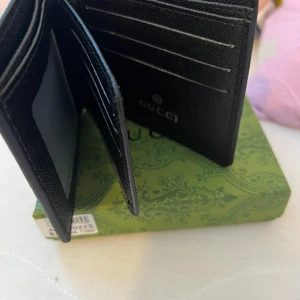  Plånbok med ormmotiv - Snygg plånbok med klassiskt GG-mönster i beige och brunt, dekorerad med en röd, vit och svart orm på framsidan. Plånboken har flera kortfack och plats för ID, tillverkad i tåligt skinn. Perfekt accessoar för dig som vill sticka ut.