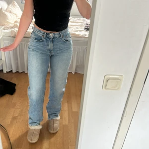 Ljusblå raka jeans med hög midja - Säljer ett par ljusblå jeans med klassisk femficksdesign och raka ben. Jeansen har hög midja och är tillverkade i ett  denimtyg. Perfekta för en chill och stilren look, passar till allt från sneakers till boots.