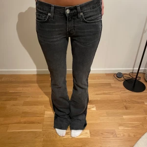 Svarta bootcut jeans med låg midja - Snygga svarta jeans med bootcut-modell och låg midja. Märket är 7 for all mankind. Super bra skick och kvalitet. Cool detalj längs sidan. Midjemått W25 och L32