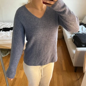 Blå stickad v-ringad tröja - Mysig blå stickad tröja med v-ringning och långa ärmar, från Vero Moda. Tröjan har en avslappnad passform och är perfekt för kyligare dagar. Enkel och stilren design som passar till det mesta.