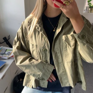 Olivgrön overshirt med fickor - Snygg olivgrön jacka med två stora bröstfickor och knäppning framtill. Jackan har en avslappnad, boxig passform och är tillverkad i bomull🩷