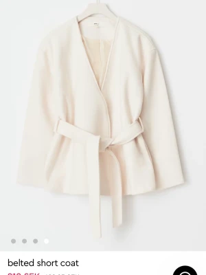 Krämvit kappa med knytskärp Gina Tricot - Stilren krämvit kappa från Gina Tricot. Den är HELT NY. EJ ANVÄND‼️Köp nu.