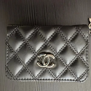 Plånbok  - Plånbok med silvrigt märke och silvrig dragkedja. Fack för kort och sedlar. Ca 13cm bred och 9cm hög. Lapp kvar, kommer med box också 