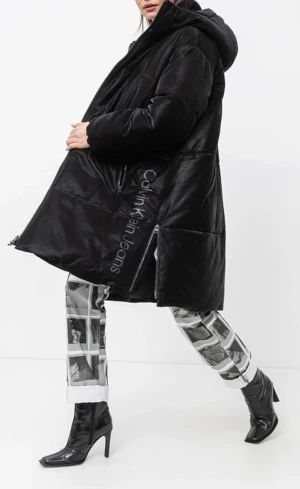 Svart pufferjacka från Calvin Klein - Svart oversized pufferjacka från Calvin Klein Jeans med huva och dragkedja framtill. Jackan har diskret logotyp längs sidan och stora fickor. Perfekt för kalla dagar med sin quiltade design och mjuka polyester-material. Mycket fint skick, inga defekter. Nypris 5000kr