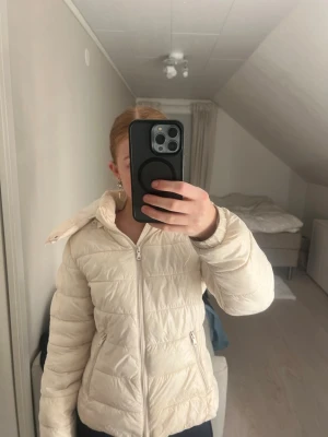 Vit pufferjacka Lager 157 - Säljer en stilren vit pufferjacka med dragkedja och två fickor framtill. Jackan har en mysig huva och quiltad design som håller dig varm under kalla dagar. Perfekt för dig som gillar en enkel och clean look. pris kan alltid diskuteras💕