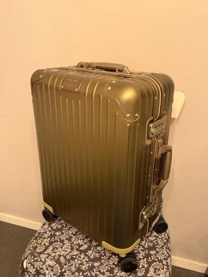 Olivgrön resväska från Rimowa - Snygg olivgrön resväska från Rimowa i aluminium med räfflad yta och robusta hörn. Väskan har fyra hjul, två handtag och integrerade TSA-lås. Perfekt för dig som vill resa med stil och kvalitet. Väskan är i princip helt ny , den super snygg och perfekt för dig som vill resa med stil , inget kvitto då jag köpte den från andra hans marknaden och säljaren hade ej kvitto . Träffas i Göteborg eller post via PostNord . Ny pris är 13500 mitt pris är 6200