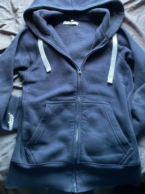Russemerch Hoodie - Tjenare, säljer denna stilrena Russemerch hoodien en av de skönaste hoodies jag har ägt. Snygg stor luva med vita snören, hoodien har en väldigt unik stil som många söker, enda lilla skavanken med denna hoodie är att de finns två små hål vid vänstra armen men inget som syns när man bär hoodien. Hör gärna av er vid frågor!