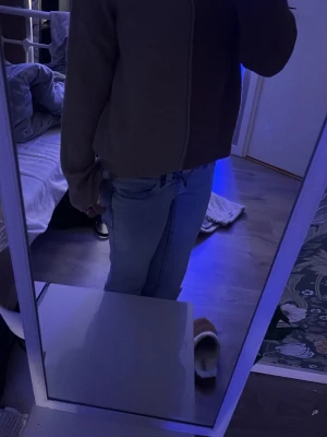 Tvåfärgad stickad tröja med glitter - Stickad tröja i två färger, ena sidan brun och andra sidan beige med glittrig effekt. Tröjan har hög hals och lång ärm, samt en rak och avslappnad passform. Perfekt för dig som gillar neutrala toner med en twist. Materialet är mjukt och bekvämt.