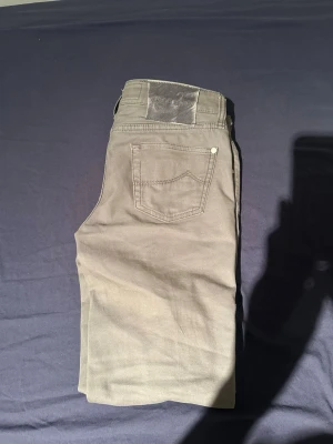 Gråa raka jeans från Jacob Cohen - Snygga gråa jeans från Jacob Cohen med klassisk femficksdesign och raka ben. Jeansen har en diskret logotyp på bakfickan och patch i läder bak i midjan. Tillverkade i ett mjukt bomullsmaterial med stretch för extra komfort.