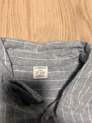 Blå skjorta från Lindex - En blå skjorta med randiga ränder, inga som helst problem med den. st 164/158