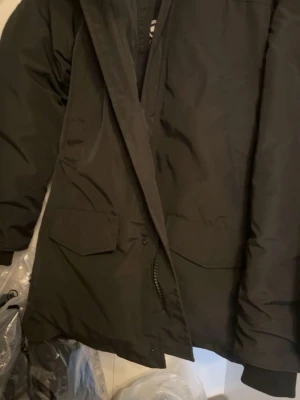 Svart parkas från Canada Goose - Säljer en svart parkas från Canada Goose st XL men passar L helt ny 