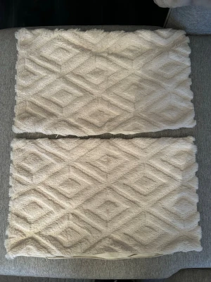2-pack beiga kuddfodral med mönster från SHEIN  - Två stycken rektangulära kuddfodral i beige färg med ett snyggt geometriskt mönster på framsidan och slät baksida från SHEIN. Materialet är mjukt och har en lätt fluffig känsla. Måtten på kuddfodralen är 30x50. 