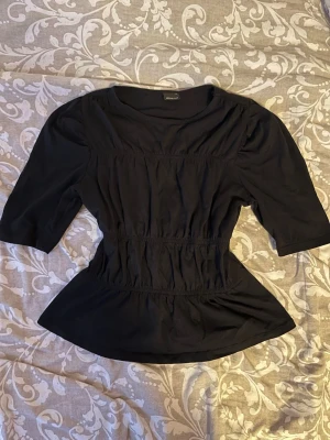Peplum topp  - Jättefin svart topp från Gina Tricot i storlek S💕Den är stretchig och helt oanvänd! Hör av dig vid frågor eller funderingar🙏🏻