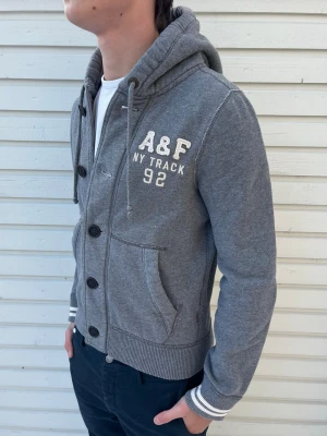 Abercrombie & Fitch kofta - Tja! Säljer nu denna sjukt snygga abercrombie&firch kofta. Skick 8.5/10 riktigt bra utan synliga defekter. Modellen är 181 men passar allt mellan 165-177 som bäst. Hör av er vid funderingar!