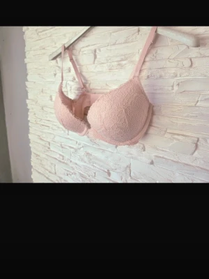 Ljusrosa spets-bh från victoria’s secret - Säljer en ljusrosa bh med vadderade kupor och vacker spetsdetalj över hela ytan. Bh:n har justerbara axelband och bygel för extra stöd. Jag köpte på vinted men passa rinte mig så därför säljer jag.