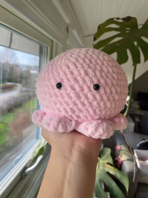 Virkad rosa bläckfisk plushie - Supermjuk och söt rosa bläckfisk plushie, virkad i fluffigt garn. Perfekt som present eller som dekoration. Unik design med svarta plastögon. 