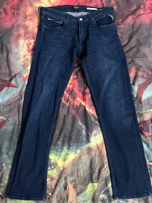 Replay jeans - Snygga mörkblå jeans från Replay, modell Grover med straight fit. Klassisk femficksdesign, silverfärgade detaljer och diskret Replay-logga vid fickan. Jeansen har normal passform och är tillverkade i slitstarkt denimtyg. Dessutom är de väldigt stretchiga så vad för rörelse du än gör kommer de inte rivas sönder. Självklart tvättas de innan de fraktas. Skriv gärna om du vill diskutera priset!