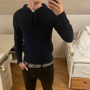 Mörkblå hoodie från Carmès i kashmir  - Säljer en stilren mörkblå hoodie från Carmès i kashmir. Tröjan har huva med snörning och långa ärmar. Perfekt för dig som gillar en enkel och clean look med en lite tightare passform. Passar dig som vill ha något både bekvämt och snyggt. Är villig att gå ner i pris!