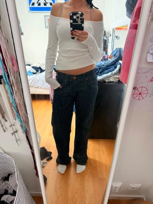 Replay Grover mörkblå jeans - Säljer ett par Replay Grover jeans i mörkblå tvätt med kontrastsömmar och cool detalj på bakfickan. Modellen har låg midja och raka, lite loose ben. Klassisk femficksdesign och robust jeansmaterial. Perfekt för dig som gillar street och avslappnad stil.