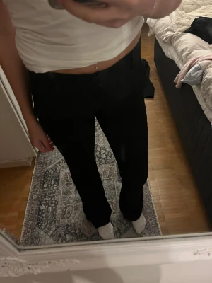 Svarta kostymbyxor från BikBok - Säljer mina svarta lågmidjade kostymbyxor från BikBok i modellen Vera med slit. älskar dem men  tyvärr blivit för små.
