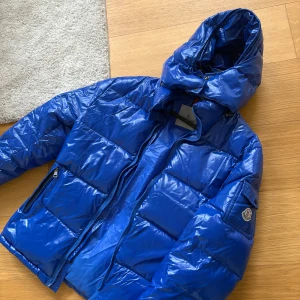 Blå dunjacka från monclear  - Använt skick därav att jag säljer billigt. Dragkedjan fungerar inte, samt att det är ett hål i vänster ficka.. Annars är den så fin och varm till vintern! Har strl S i vanliga fall och denna passar perfekt för mig! 