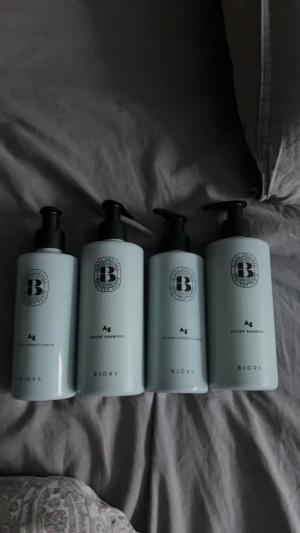 Björk Silver Shampoo & Conditioner - Fyra ljusblå flaskor från Björk, två Silver Shampoo och två Silver Conditioner. Flaskorna har stilren design med svart pump och tydlig logga. Perfekt för dig som vill behålla kalla toner i håret och motverka gula nyanser.HELT OANDVÄNDA