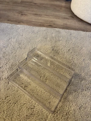 Trappstegsformad förvaringshylla i plast - Jätte bra, jag använder min för parfymer men den kan såklart användas för andra saker! 