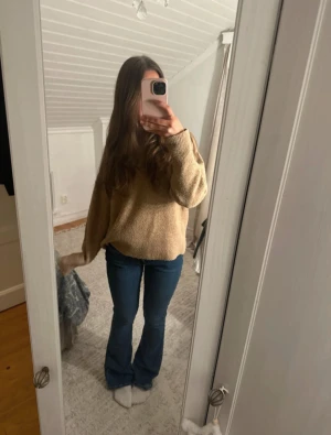 Blå bootcut jeans med låg midja - Säljer ett par snygga blå jeans med bootcut passform och låg midja. Jeansen har klassisk femficksdesign och är tillverkade i ett stretchigt denim-material som sitter skönt. Perfekta för dig som gillar en retro vibe och vill ha ett par jeans som framhäver benen.